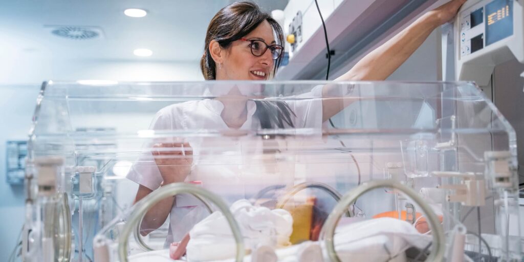 medical worker examines a child in the pediatric intensive care unit