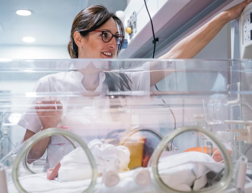 medical worker examines a child in the pediatric intensive care unit